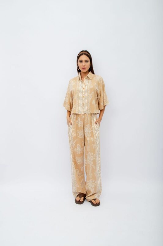 Conjunto Flora contém calça pantalona com elástico no cós e bolsos laterais. A camisa cropped com botões complementa o look, trazendo um toque moderno.
