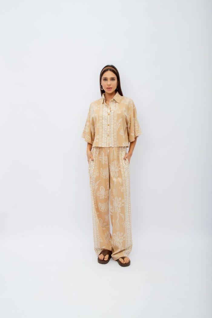Conjunto Flora contém calça pantalona com elástico no cós e bolsos laterais. A camisa cropped com botões complementa o look, trazendo um toque moderno.