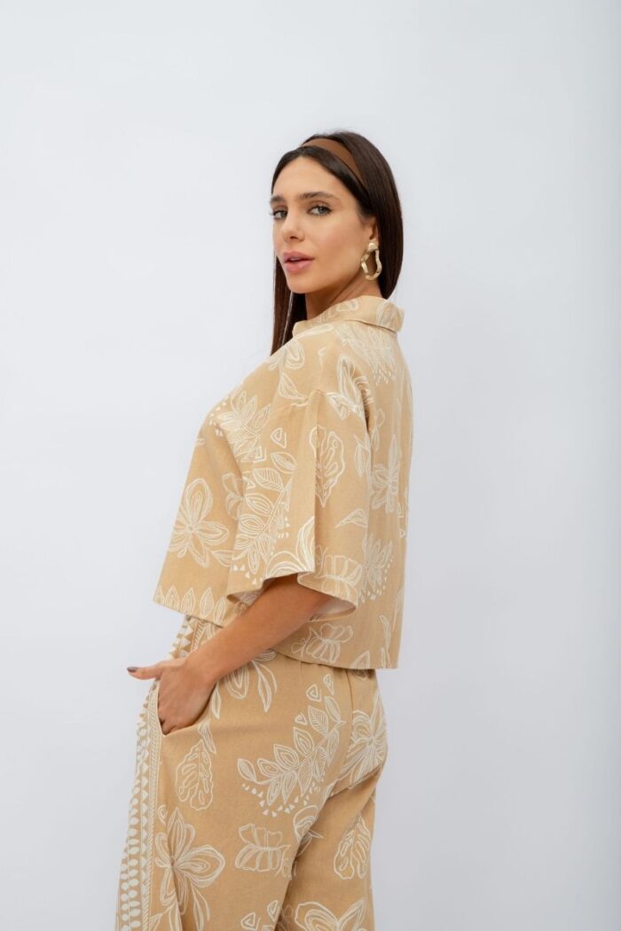 Conjunto Flora contém calça pantalona com elástico no cós e bolsos laterais. A camisa cropped com botões complementa o look, trazendo um toque moderno.