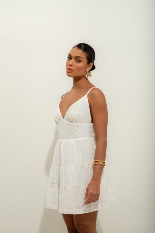 Vestido Elis é curto, forrado e feito em laise de algodão, com alças reguláveis, elástico e amarração nas costas, oferecendo conforto e um ajuste perfeito