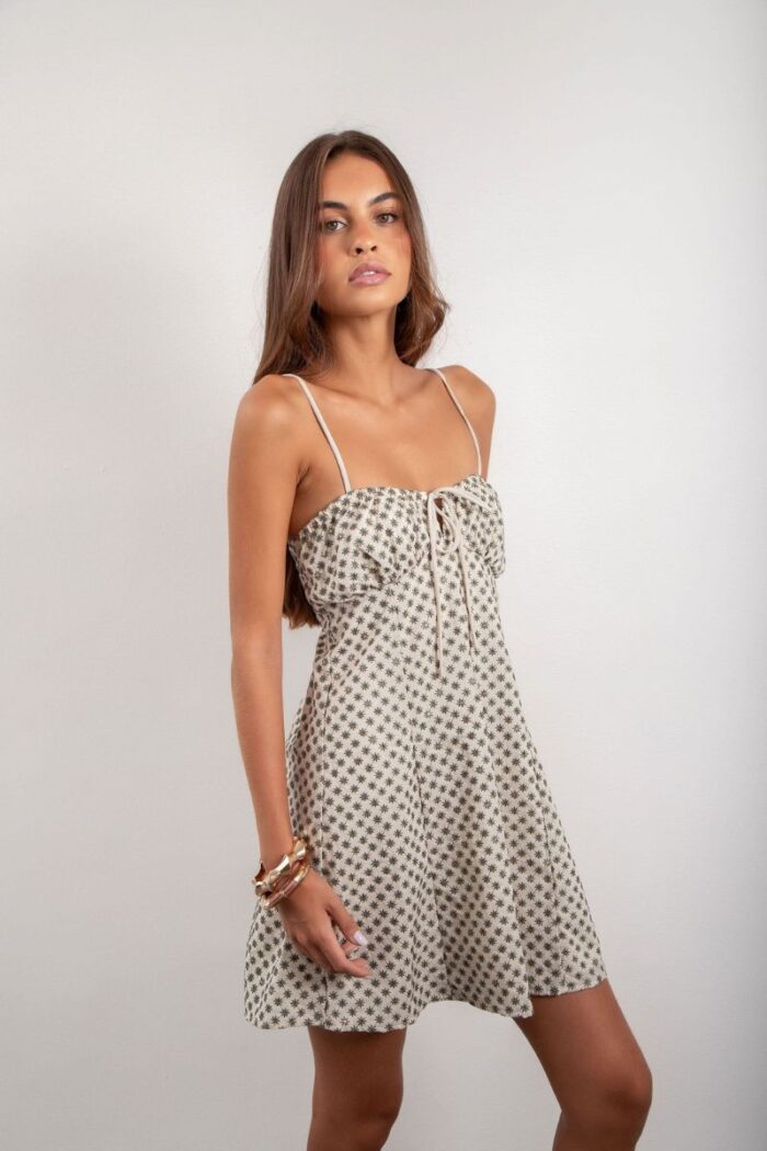 Vestido Elis é curto, forrado e feito em laise de algodão, com alças reguláveis, elástico e amarração nas costas, oferecendo conforto e um ajuste perfeito.