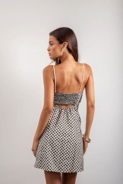 Vestido Elis é curto, forrado e feito em laise de algodão, com alças reguláveis, elástico e amarração nas costas, oferecendo conforto e um ajuste perfeito.