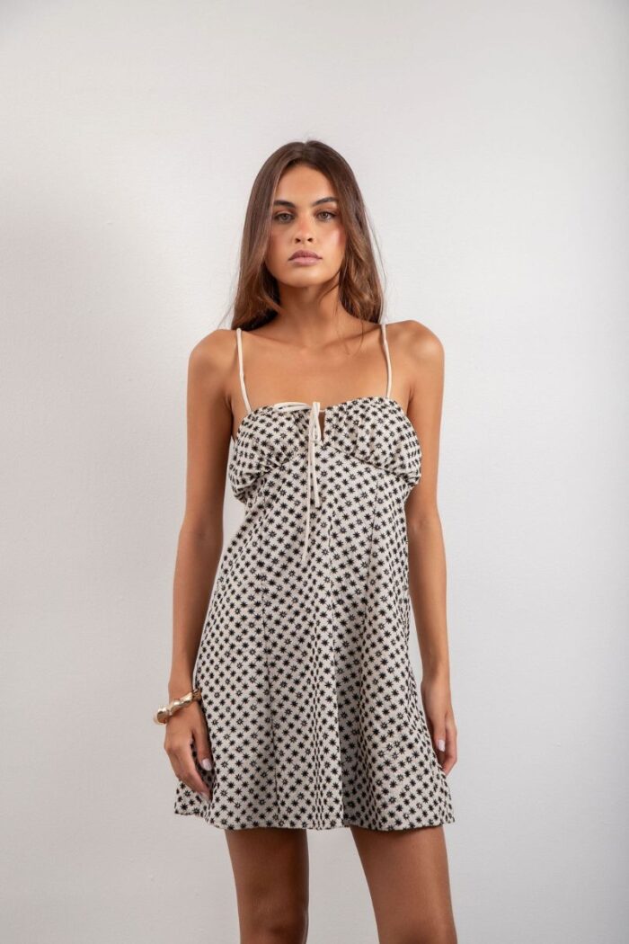 Vestido Elis é curto, forrado e feito em laise de algodão, com alças reguláveis, elástico e amarração nas costas, oferecendo conforto e um ajuste perfeito.