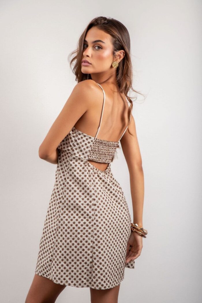 Vestido Elis é curto, forrado e feito em laise de algodão, com alças reguláveis, elástico e amarração nas costas, oferecendo conforto e um ajuste perfeito.