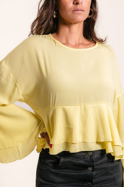 Blusa com manga comprida, babados na manga e na barra.